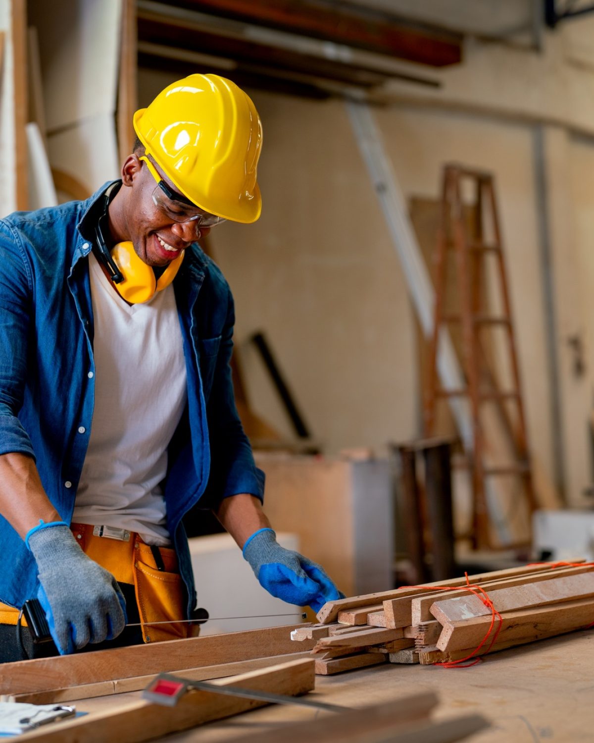 African American carpenter man look happy to work with timber in factory workplace